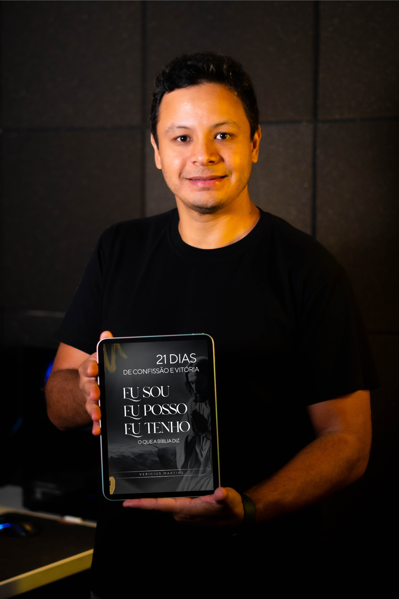 Verícius Martins segurando o e-book em um tablet